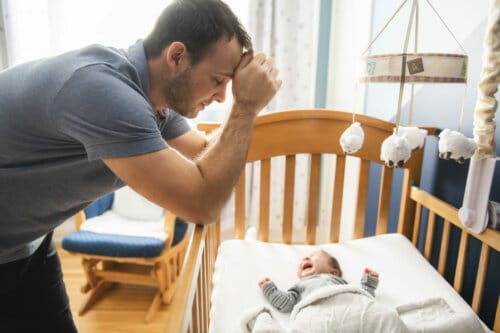 A Tired father with Upset Baby Suffering with Post Natal Depression.
