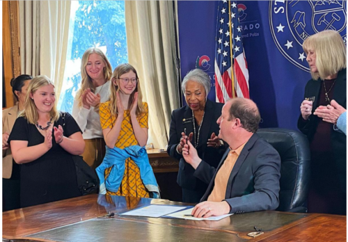 Gov. Jared Polis signs Reasonable Independence for Children law. Photo courtesy of Hannah Metzger / Colorado Politics.