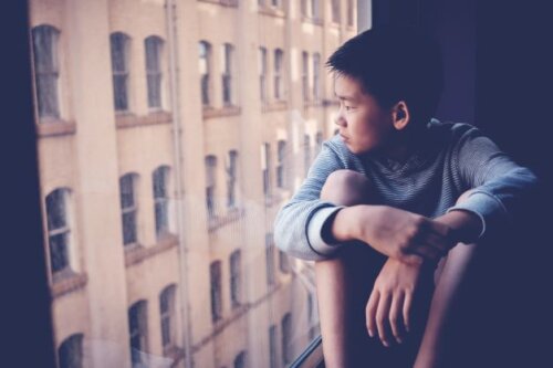 Bored Asian Kid In Window AdobeStock_332291479